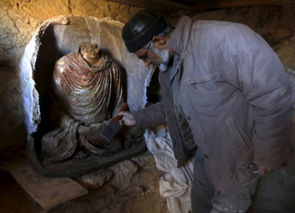 FILE PHOTO: An Afghan archeologist cleans a headless Buddha statue discovered inside an ancient temple in Mes Aynak, Logar province February 14, 2015. Photo by Omar Sobhani/Reuters