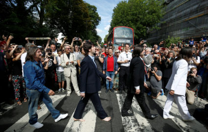 People take pictures as the Beatles cover band members walk on the zebra crossing on Abbey Road in London, Britain August 8, 2019. Photo by REUTERS/Henry Nicholls
