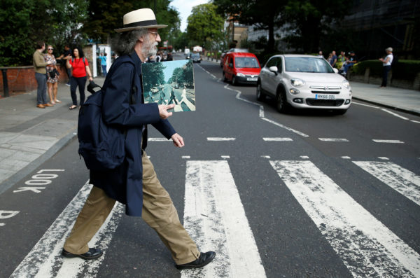 A man holds the iconic Beatles photo on Abbey Road as he recreates the photograph on the zebra crossing in London, Britain, in August. Henry Nicholls/Reuters