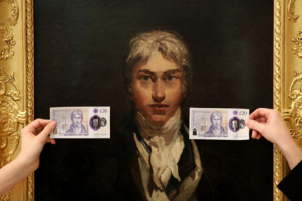 Employees hold the new 20 pound note featuring artist J.M.W. Turner in front of Turner's self portrait at the Tate Britain in London, Britain. Photo by Simon Dawson/Reuters