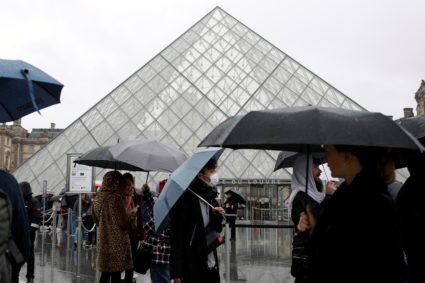 A tourist wearing a mask walks away from the Louvre as the staff closed the museum during a staff meeting about the coronavirus outbreak, in Paris, France, March 2, 2020. Photo by Benoit Tessier/Reuters