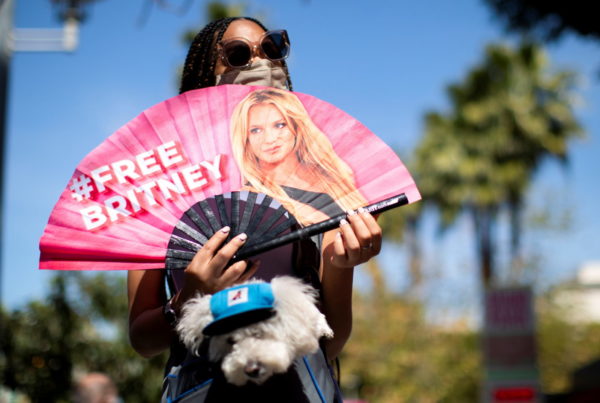 FILE PHOTO: A supporter holds a fan while rallying for pop star Britney Spears during a conservatorship case hearing at St...