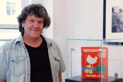 Woodstock producer Michael Lang poses during a photo exhibit that celebrates the 50th anniversary of Woodstock in New York