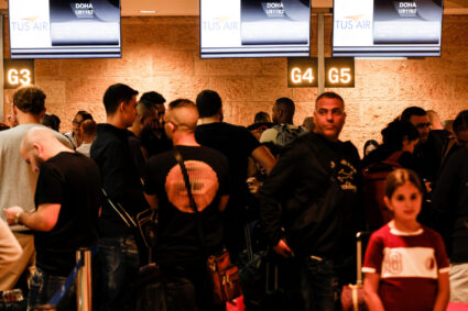 Football fans queue before boarding the first direct commercial flight between Israel and Qatar for the upcoming 2022 FIFA...