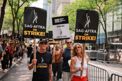 SAG-AFTRA actors and Writers Guild of America (WGA) writers walk while on strike outside NBC Studios in New York City