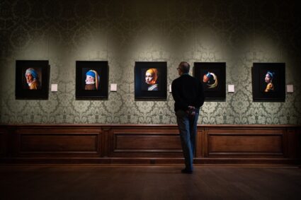 A museum's staff looks at an image designed with artificial intelligence by Berlin-based digital creator Julian van Dieken, inspired by Johannes Vermeer's painting "Girl with a Pearl Earring", at the Mauritshuis museum in The Hague on March 9, 2023. Photo by Simon Wohlfahrt/AFP via Getty Images